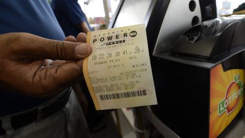 A retailer holds a Powerball lottery ticket at a store in Decatur, Georgia, on Friday, May 17. The multistate Powerball jackpot was $590.5 million, with a cash value of $376.9 million, according to the Multi-State Lottery Association.