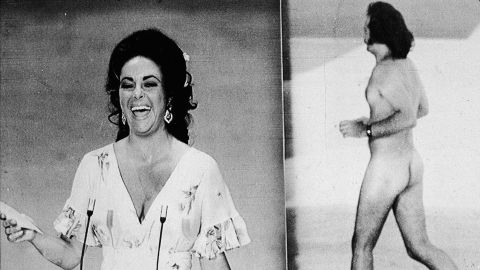 Elizabeth Taylor laughs as she was upstaged by a streaker before presenting the Oscar for best picture.