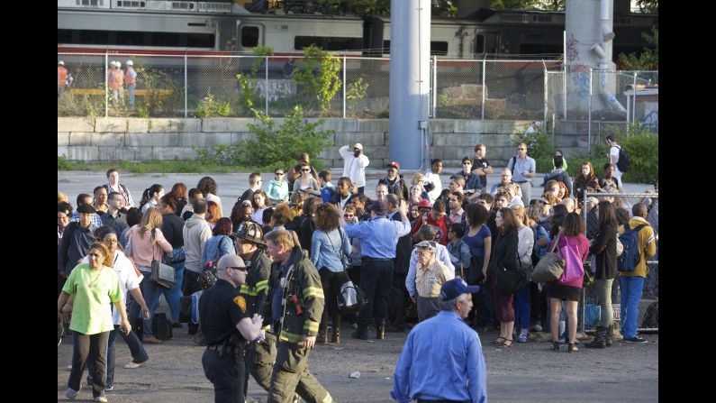 Passengers gather as they wait for a bus to pick them up from the scene of the collision.