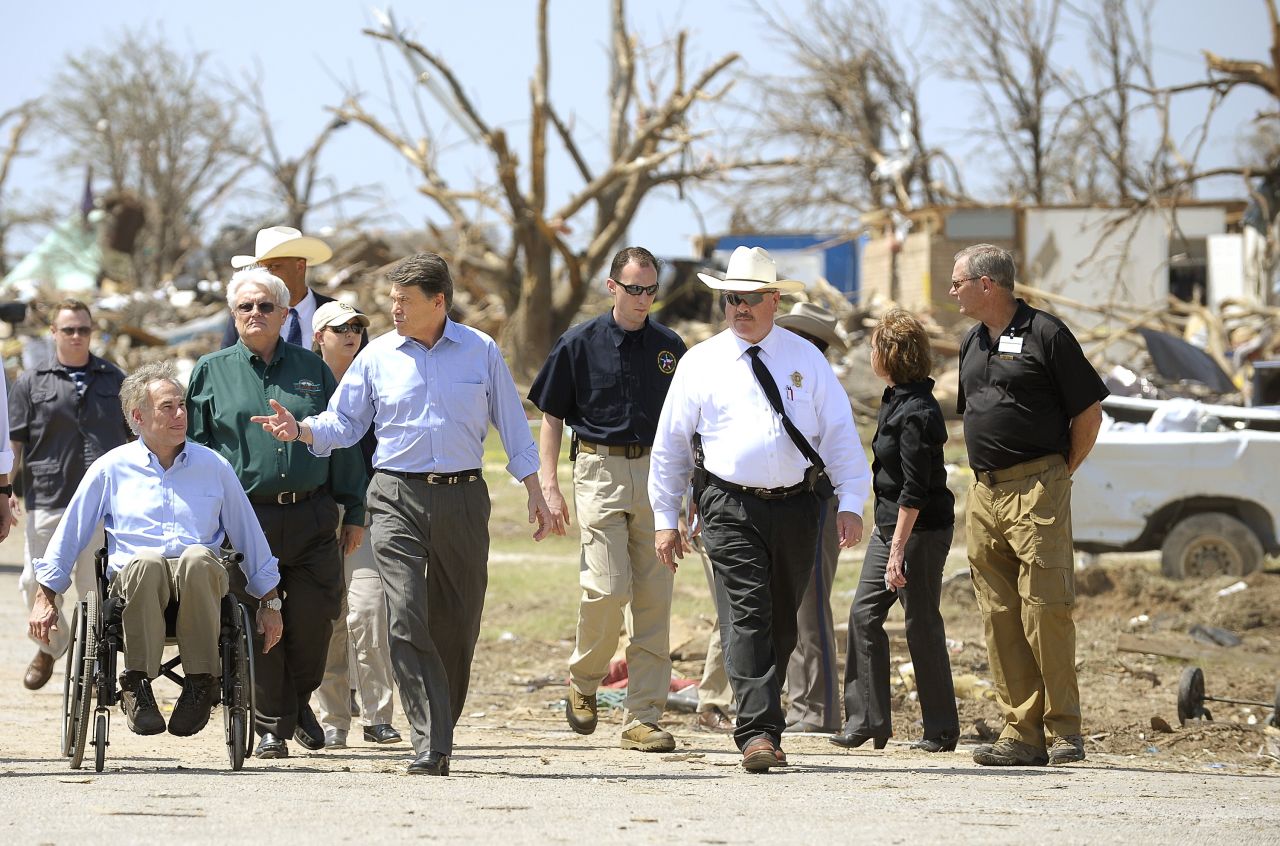 Texas Gov. Rick Perry, center, and Texas Attorney General Greg Abbott, left, survey the tornado damage in the Rancho Brazos Estates subdivision near Granbury, Texas, on Friday, May 17. At least six people were killed in a string of tornadoes that struck overnight Wednesday in North Texas.