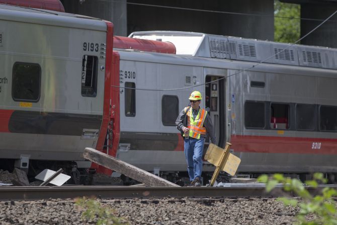 A Connecticut state investigator examines the scene of a Metro-North train collision on Saturday, May 18, in Fairfield, Connecticut. Two commuter trains collided during rush hour on Friday, sending dozens to the hospitals and shutting down a busy section of track, which is expected to affect commuters for weeks to come. 