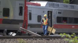 A Connecticut state investigator examines the scene of a Metro-North train collision on Saturday, May 18, in Fairfield, Connecticut. Two commuter trains collided during rush hour on Friday, sending dozens to the hospitals and shutting down a busy section of track, which is expected to affect commuters for weeks to come. 