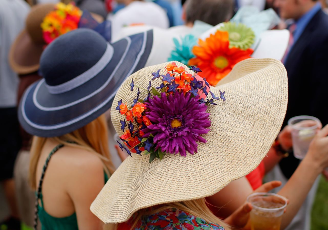 Fans wearing festive hats enjoy the festivities prior to the Preakness Stakes. 