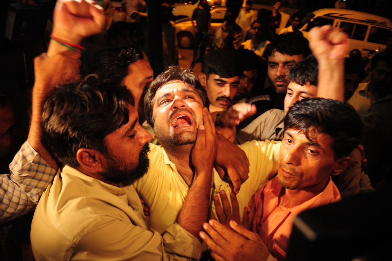 Members of the Tehreek-e-Insaf party mourn the death of Zahra Shahid Hussain, vice president of the party, outside a hospital in Karachi, Pakistan, on Saturday, May 18. Hussain had alleged vote-rigging in the May 11 elections.
