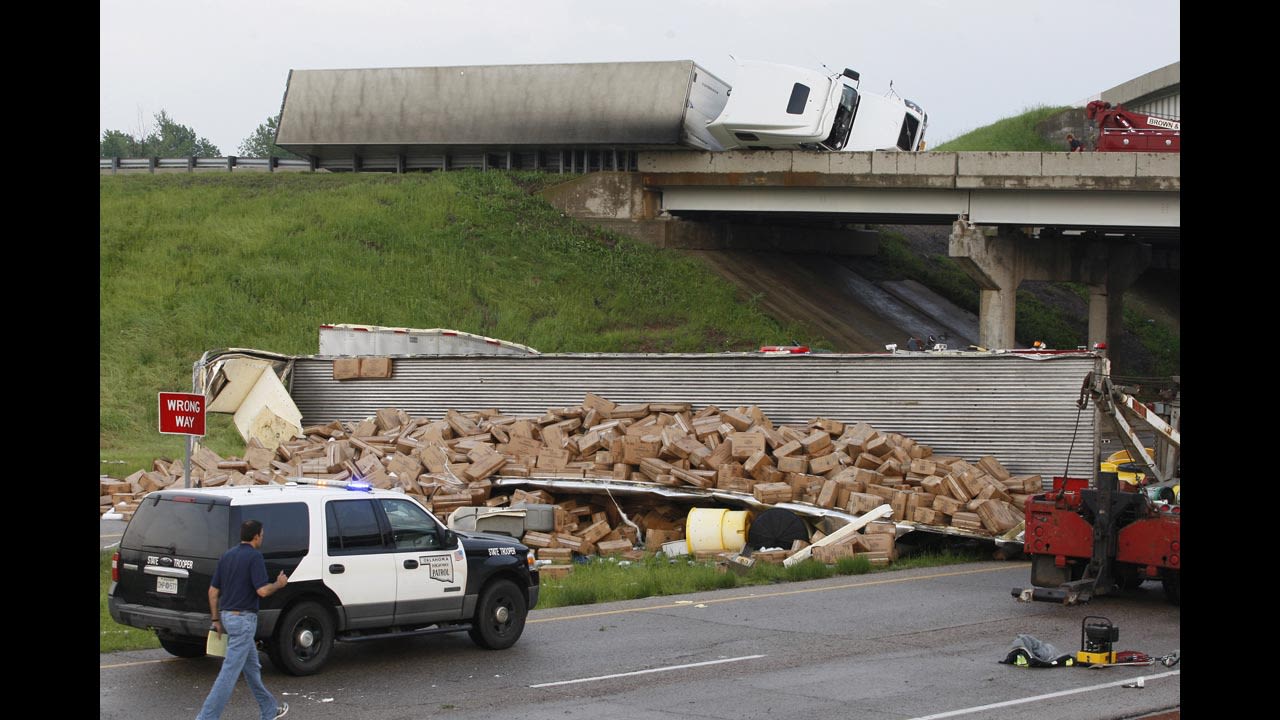 A tractor-trailer lies on its side on Interstate 40 while another is broken open on the road below after falling from the overpass after a tornado strike near Highway 177 north of Shawnee on May 19.