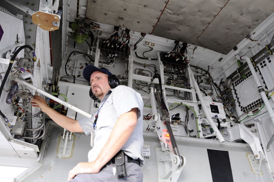 A United Airlines maintenance worker examines a hydraulic line. 