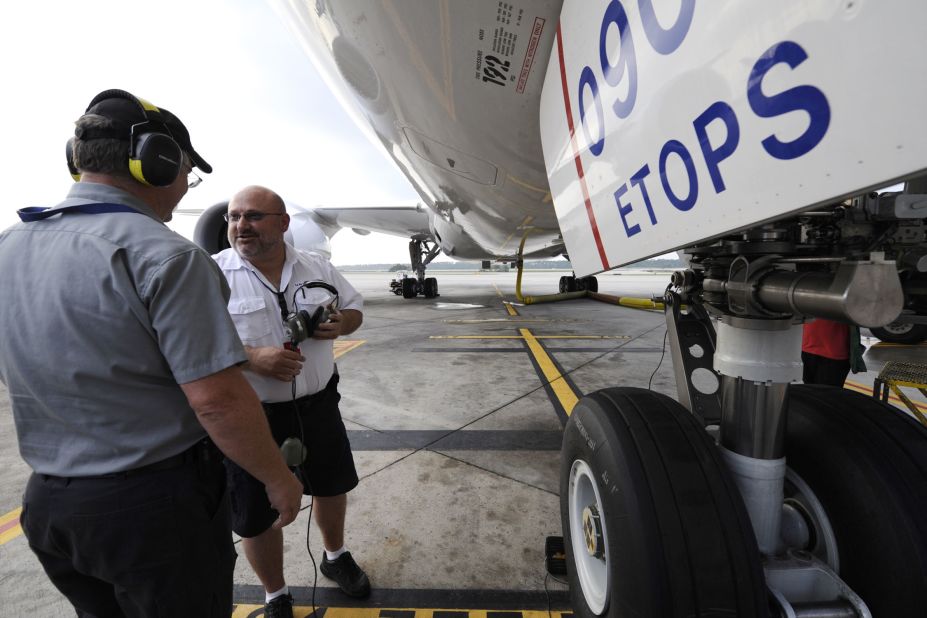 United Airlines maintenance workers prepare the plane for flight. 