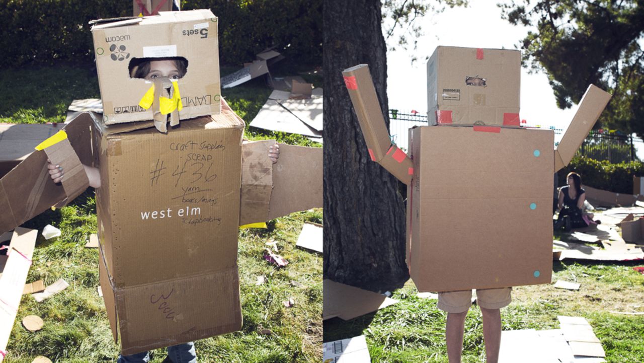 Kids make forts and costumes in the Cardboard Challenge area, a stretch of grass covered with cardboard, tape and other tools. McCawley Yarbrough, left, is a bird and Gabriel Wilson is a robot.