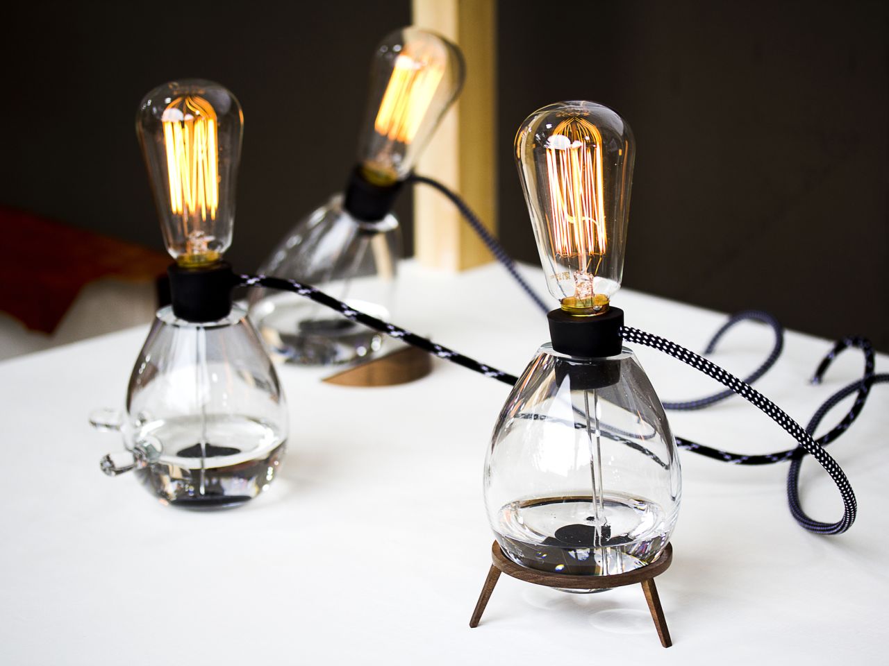 Designer Patrick Stevenson-Keating developed a conductive paint-powered lamp for the 2012 Milan Furniture Fair. The lamp consists of a layer of liquid paint suspended in oil. When standing vertically two electrodes make contact with the conductive paint sending power to the bulb. By rotating the lamp horizontally, the contact is broken and the light goes off.