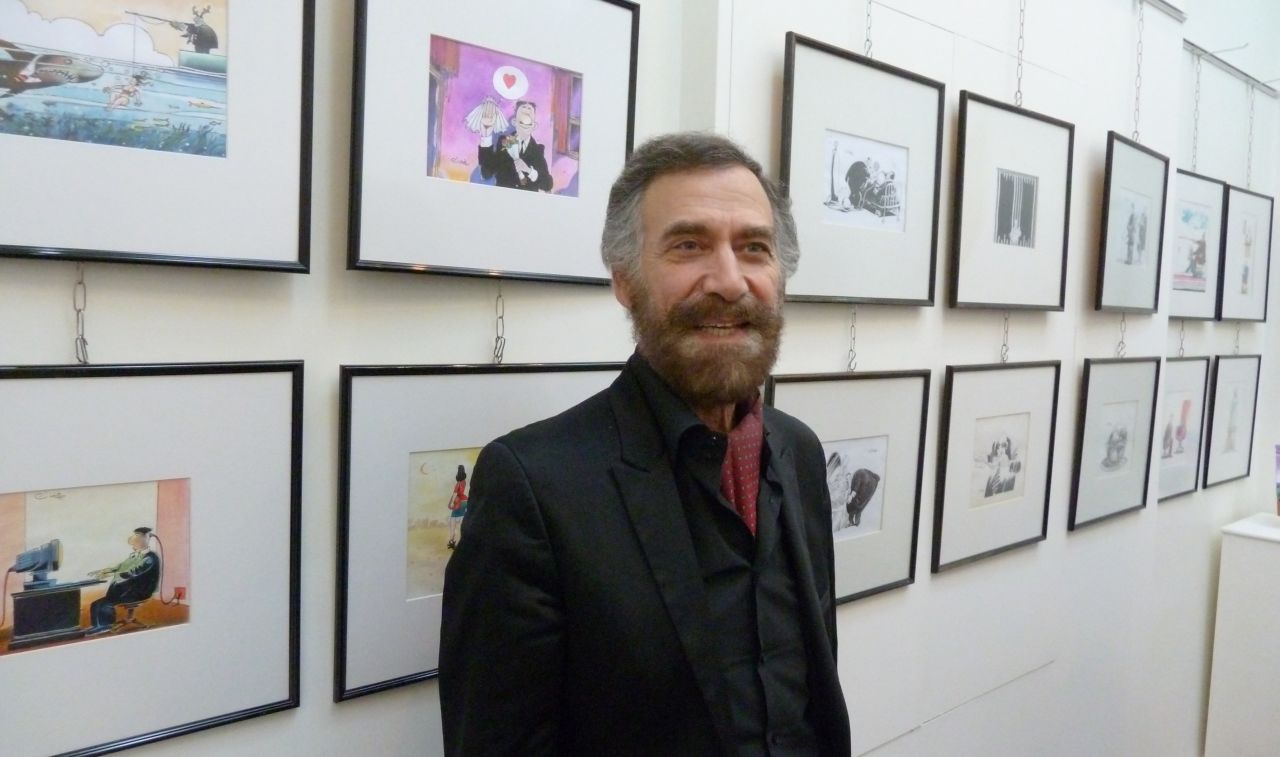 Syrian artist Ali Farzat at an exhibition of his cartoon paintings. Protesters and rebels alike have carried printouts of his work.