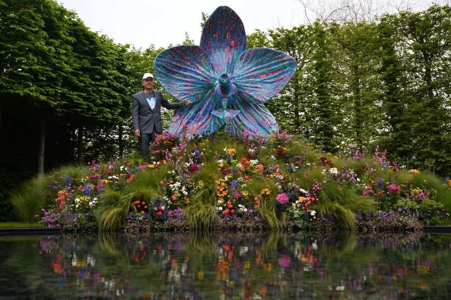 British artist Marc Quinn poses with his sculpture of an orchid in the Royal Horticultural Society garden on May 20, 2013. The world-famous gardening event is celebrating its centenary year. 