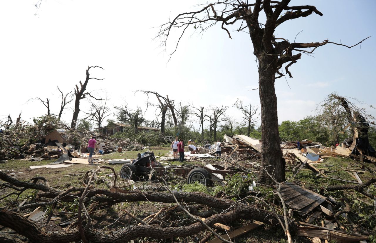 Tom and Ronda Clark get help with cleanup on May 20, after their property near Shawnee was damaged by a tornado on May 19.