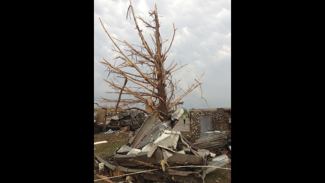 A shredded tree stands amid debris in the aftermath of the storm in Moore on May 20.