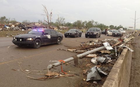 Law enforcement officers block a roadway in Moore where there was extensive damage from the tornado.