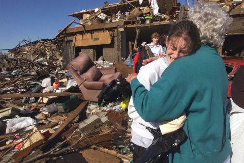 Nan Goines, right, hugs her granddaughter Ashley Thomas, on May 5, 1999, in front of the remains of her home in Midwest City, Oklahoma.