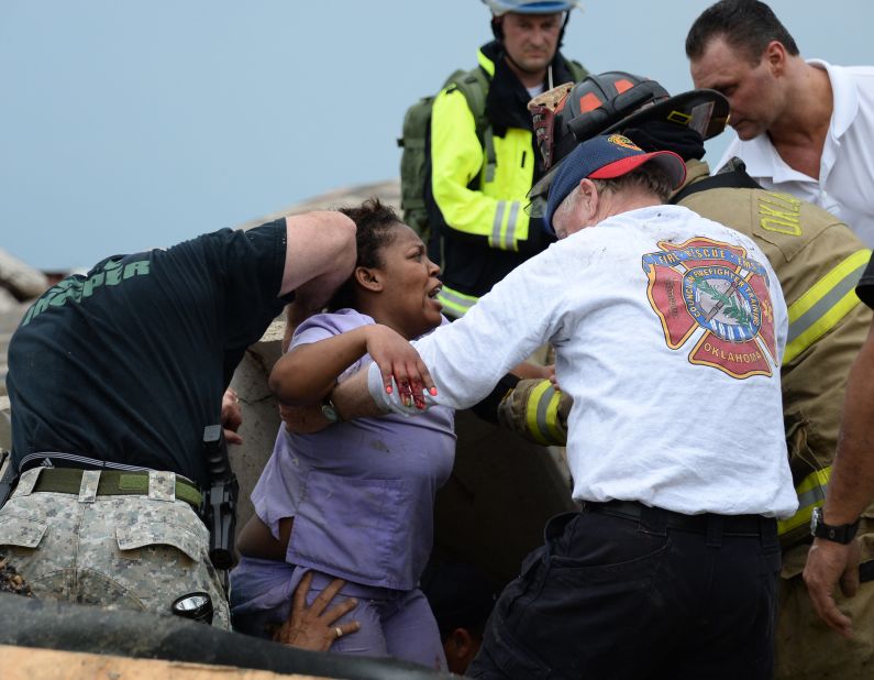Rescue workers help free one of more than a dozen people who were trapped at a medical center in Moore on May 20.