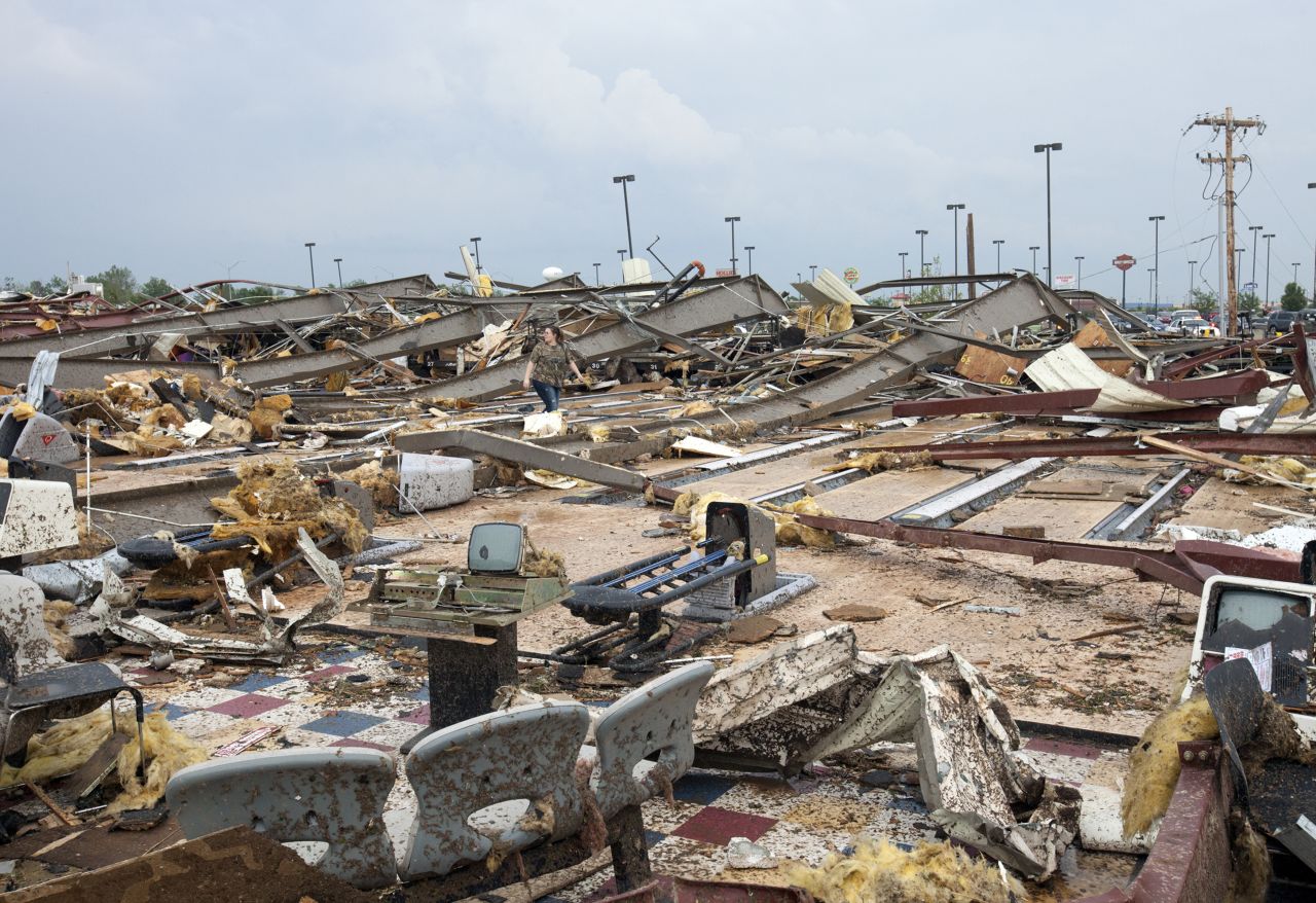 A woman walks through debris in Moore on May 20.
