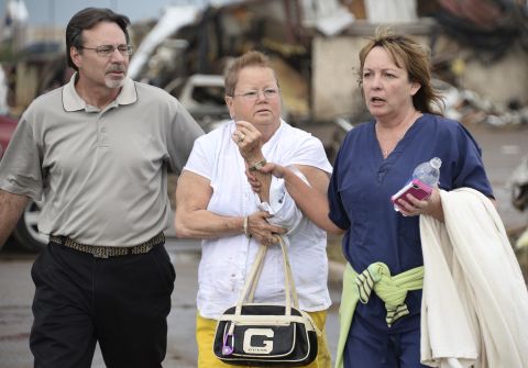 A woman with an arm injury is helped on May 20 in Moore.