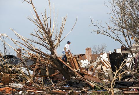 A man looks through the remains of a home after the massive tornado struck Moore on May 20.