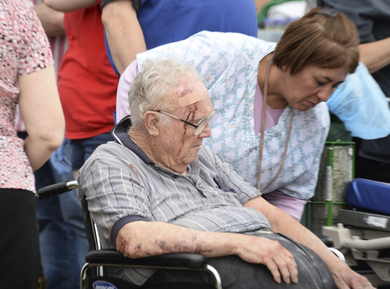 A nurse helps an older man who suffered a head injury on May 20 in Moore.