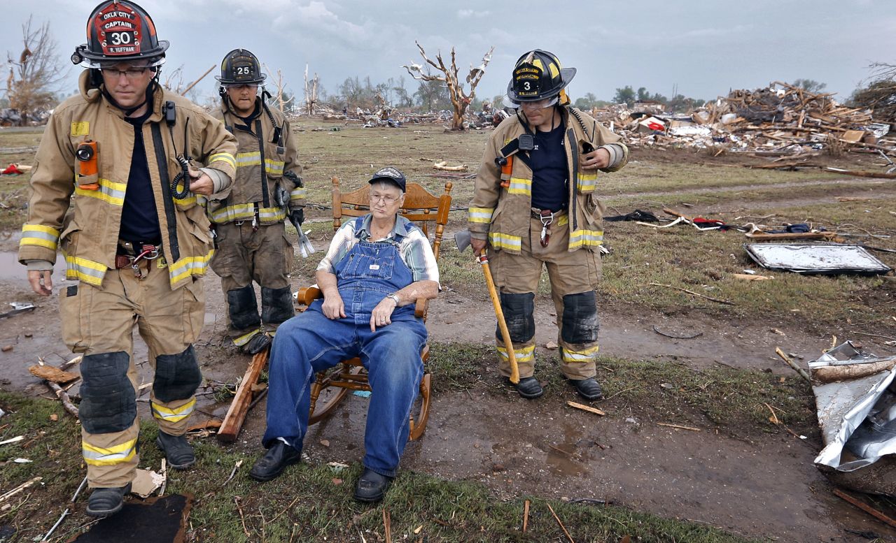 Oklahoma City firefighters check on Gene Tripp on May 20 as he sits in his rocking chair where his home once stood.
