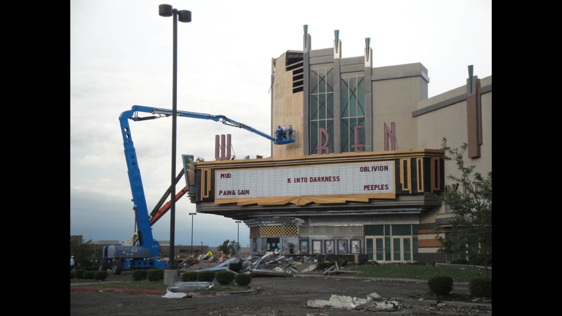 Workers clean up the Warren movie theater in Moore on May 21.