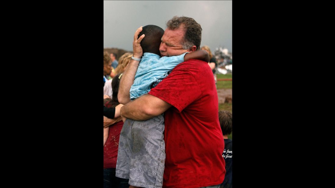 Jim Routon hugs his neighbor, 7-year-old Hezekiah, after the tornado strikes on May 20. An earlier version of this caption incorrectly stated that Routon was Hezekiah's teacher. <a href="http://outfront.blogs.cnn.com/2013/05/21/neighbors-comfort-boy-in-tornado-aftermath/">See an interview with the pair.</a><strong> </strong>