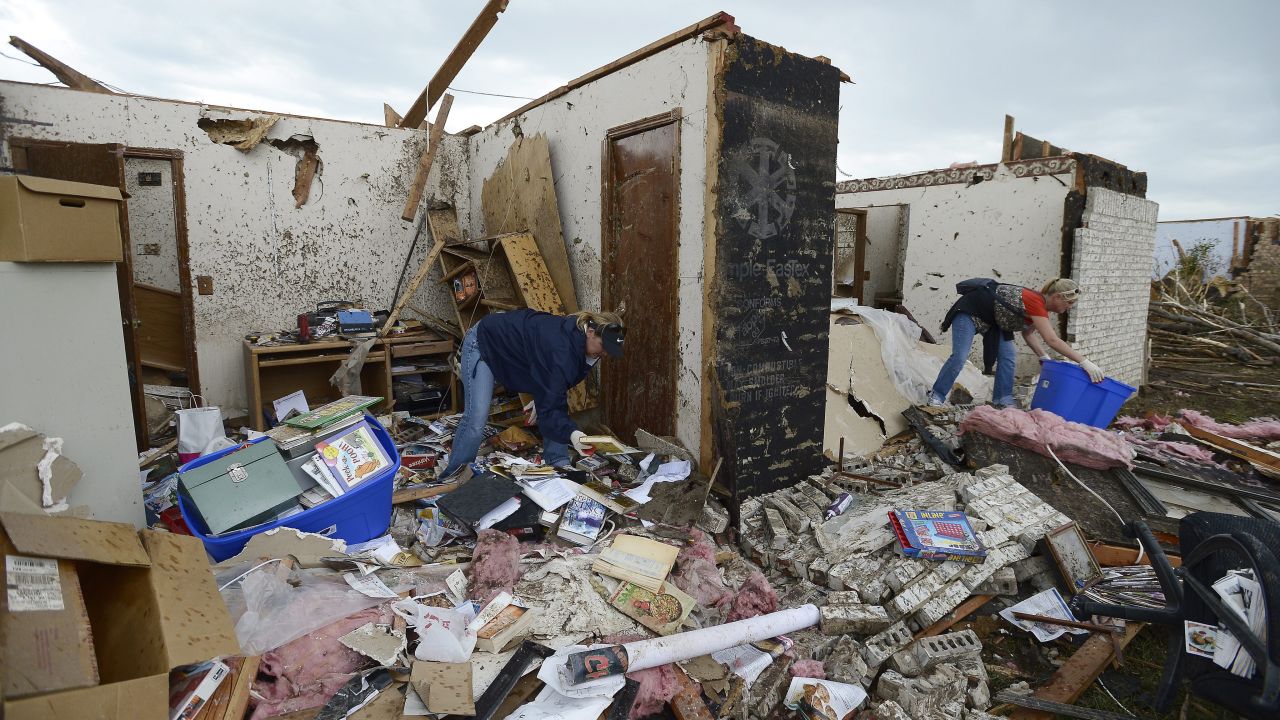 People recover belongings from the rubble of a home in Moore.