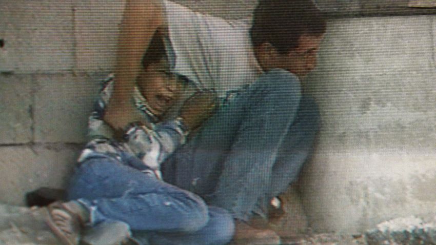 TV grab from France 2 footage of Israeli-Palestinian clashes in Netzarim in the Gaza Strip 29 September 2000 shows Jamal Al-durra and his son Mohammed, 12, hiding behind a barrel to protect themselves from Israeli-Palestinian cross fire. The boy is screaming in panic as shots hit the wall over their heads. Seconds later he was fatally struck in the abdomen. Seriously wounded, the father lost consciousness, was hospitalized in Gaza and is expected to recover. (Photo credit should read /AFP/Getty Images)