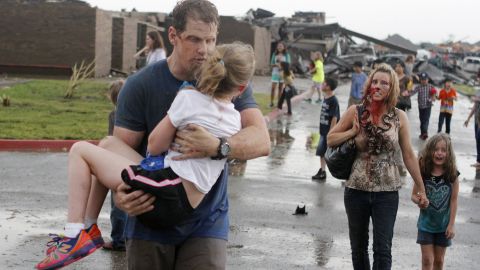 Steve and LaDonna Cobb take children away from Briarwood Elementary after a tornado destroyed the school Monday.