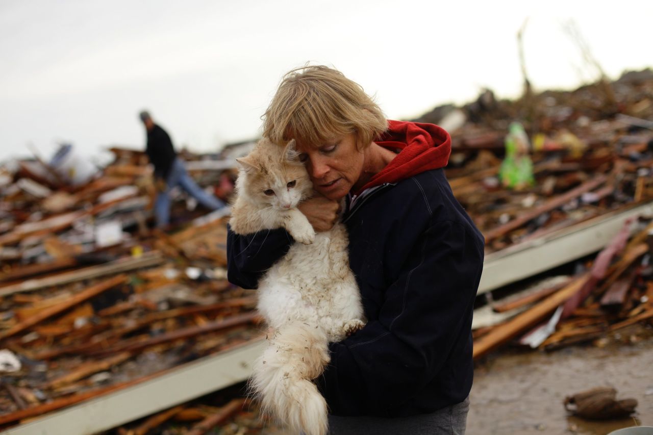 June Simson embraces her cat Sammi after she found him standing among the rubble of her destroyed home in Moore on May 21.