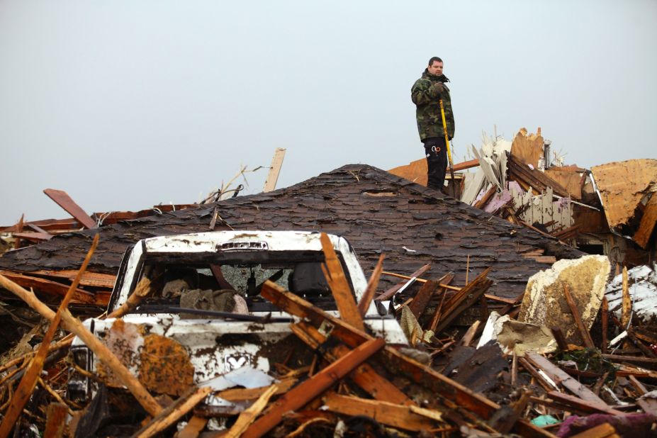 A man stands on the roof of a destroyed home in Moore on May 21.