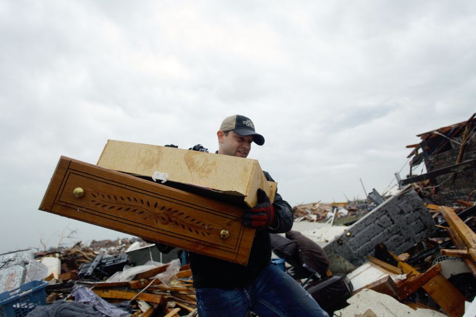 A man helps move a resident's belongings from a destroyed home on May 21 in Moore.