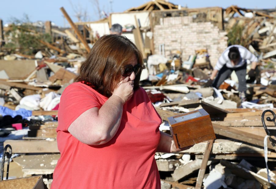 Kelli Kannady weeps after finding a box of photographs of her late husband in the rubble near where her home once stood in Moore on May 21.