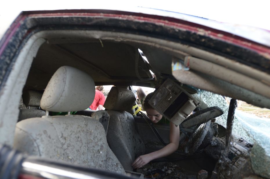 Natalie Johnson searches through her mother's destroyed car outside Briarwood Elementary School in Moore on May 21.