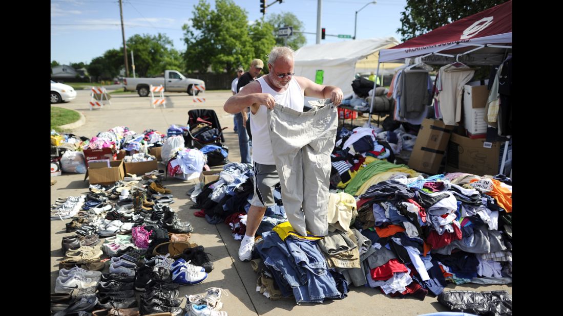 A man looks through a pile of clothing at a roadside relief camp on May 22 in Moore.