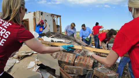 Teachers from Fairview Elementary School help clean up former school counselor Kay Taylor's home in south Oklahoma City on May 22, two days after an extremely powerful tornado tore through Moore, Oklahoma. 