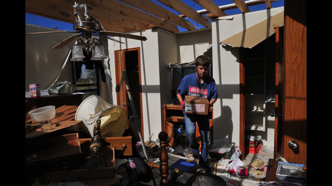 Jake English, 12, cleans up retired school counselor Kay Taylor's home on May 22 in south Oklahoma City, just west of Moore. The storm was part of a tornado outbreak that began in the Midwest and Plains on Sunday, May 19.  
