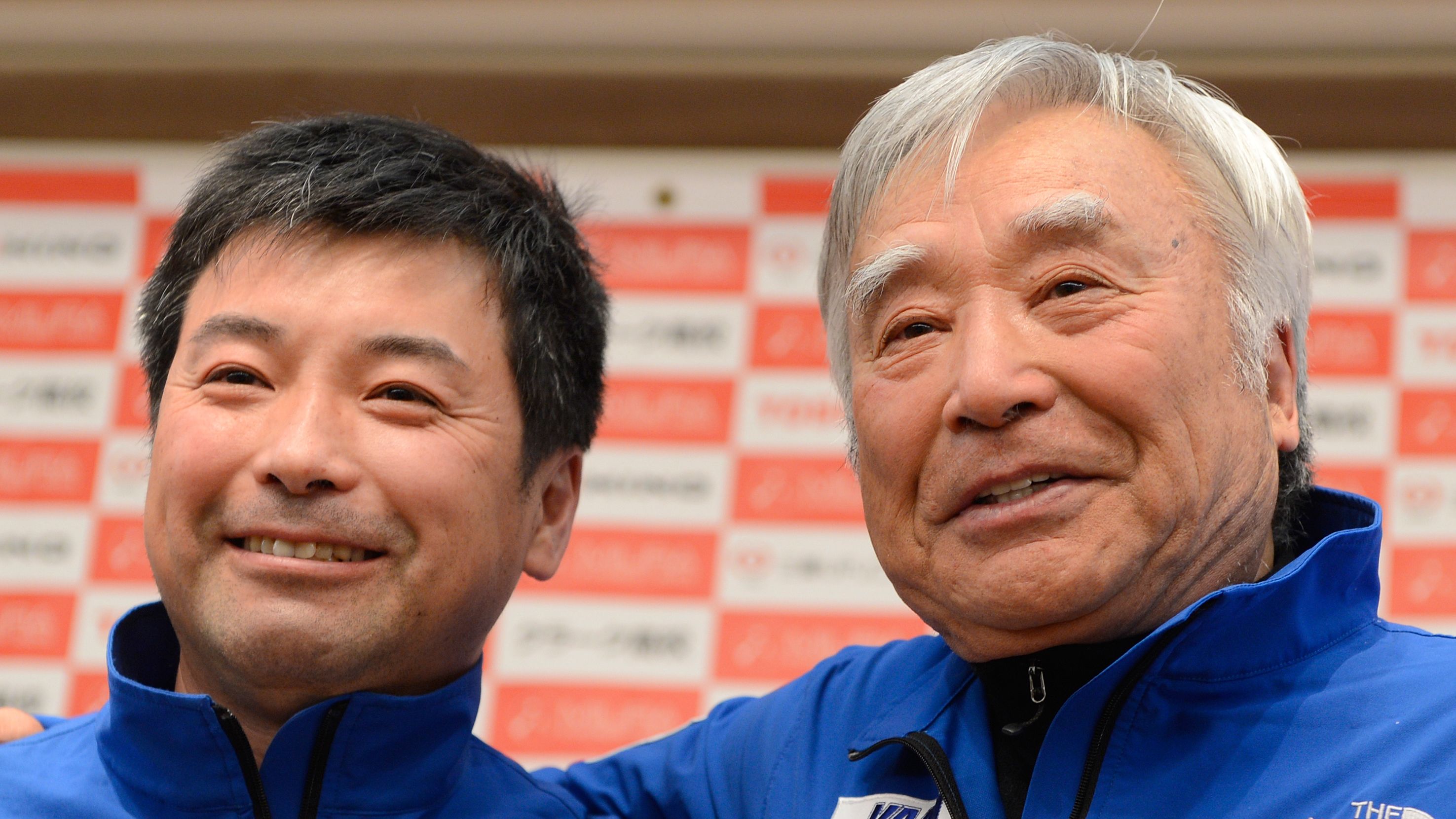 Yuichiro Miura (R) poses with his son Gota Miura (L) for photographers during a press conference in Tokyo on March 22.