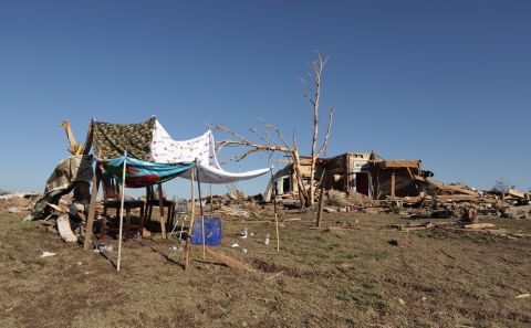 A makeshift shelter stands next to a home destroyed by the tornado on May 22.