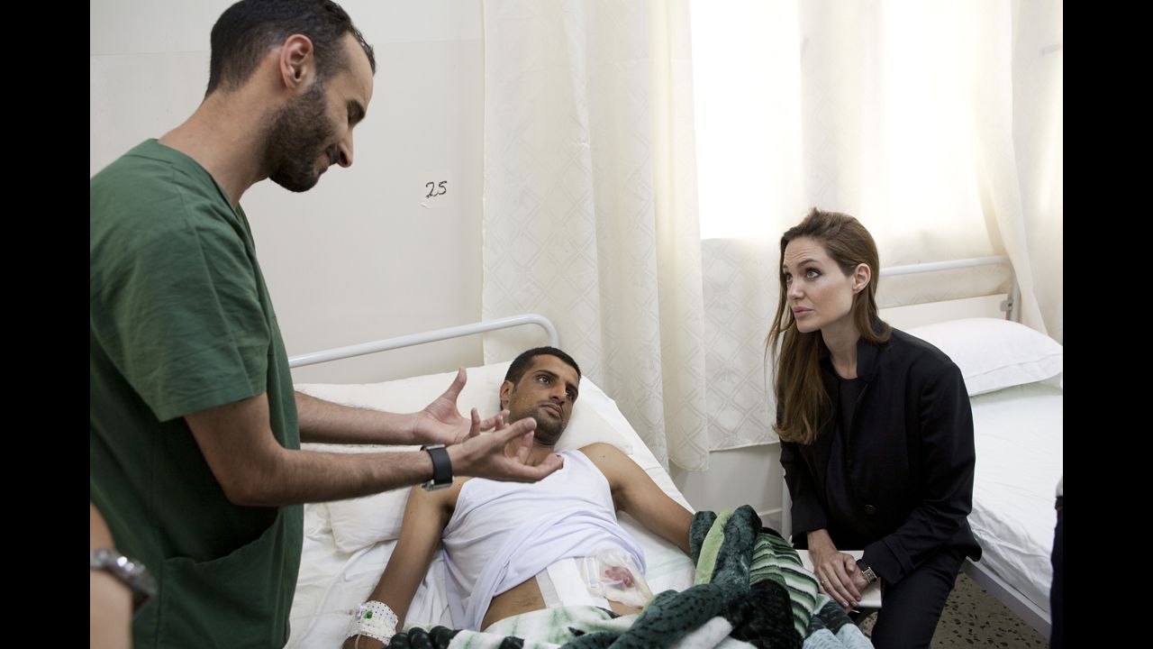 Jolie visits a man in a hospital in Misrata, Libya, in October 2011 in this handout photo provided by UNHCR.