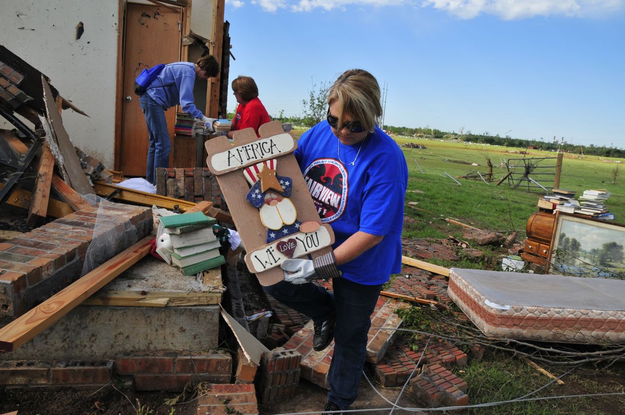Lisa Brown helps her former colleague Kay Taylor pull belongings from the wreckage of her home. Taylor, a former PE teacher and school counselor, was most concerned about finding her collections of pennies, gumball machines and ladybug figures.