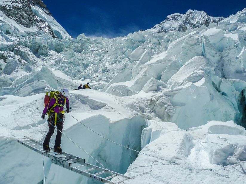 Expedition member Melissa Arnot uses a ladder to cross in the Khumbu Icefall in 2012.