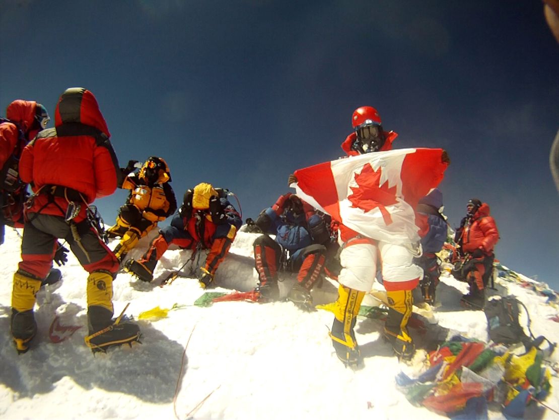 Shriya on the Everest summit, holding the Canadian flag.