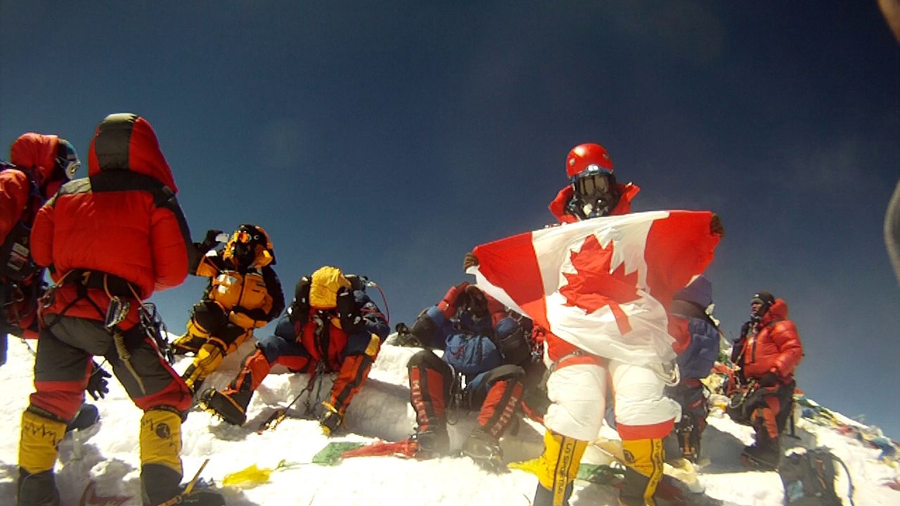 Shriya on the Everest summit, holding the Canadian flag.