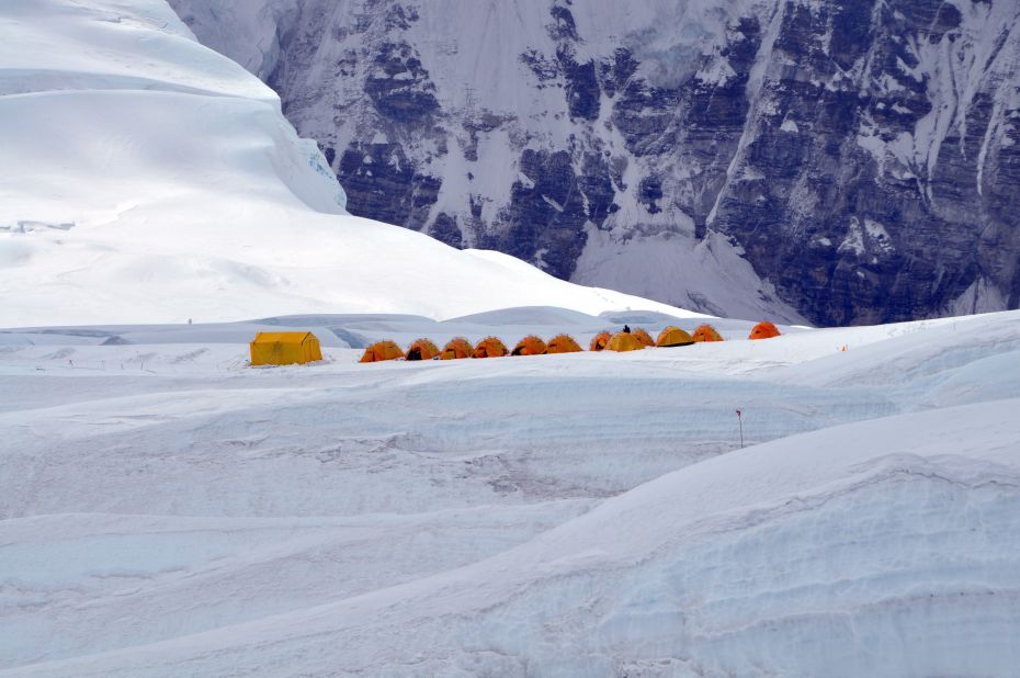 The tents from Camp 1 appear incredibly small against the backdrop of Everest.