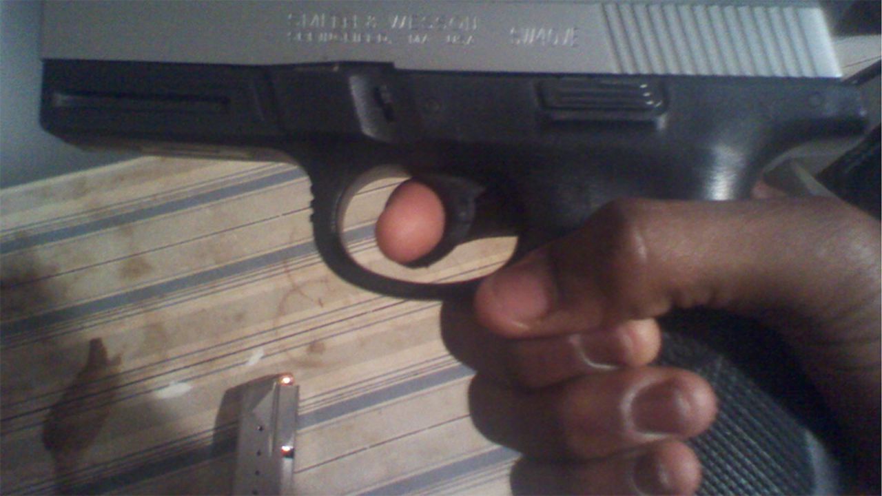 A person holds a gun in this image taken from Martin's cell phone.