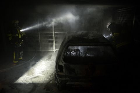 Firemen extinguish a burning car parked in an indoor garage in the Stockholm suburb of Tureberg on May 24.