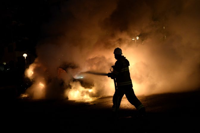 Firemen extinguish a burning car in Kista on Tuesday, May 21.