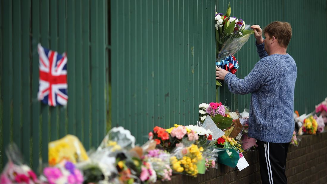 A man places flowers near the scene on May 24.